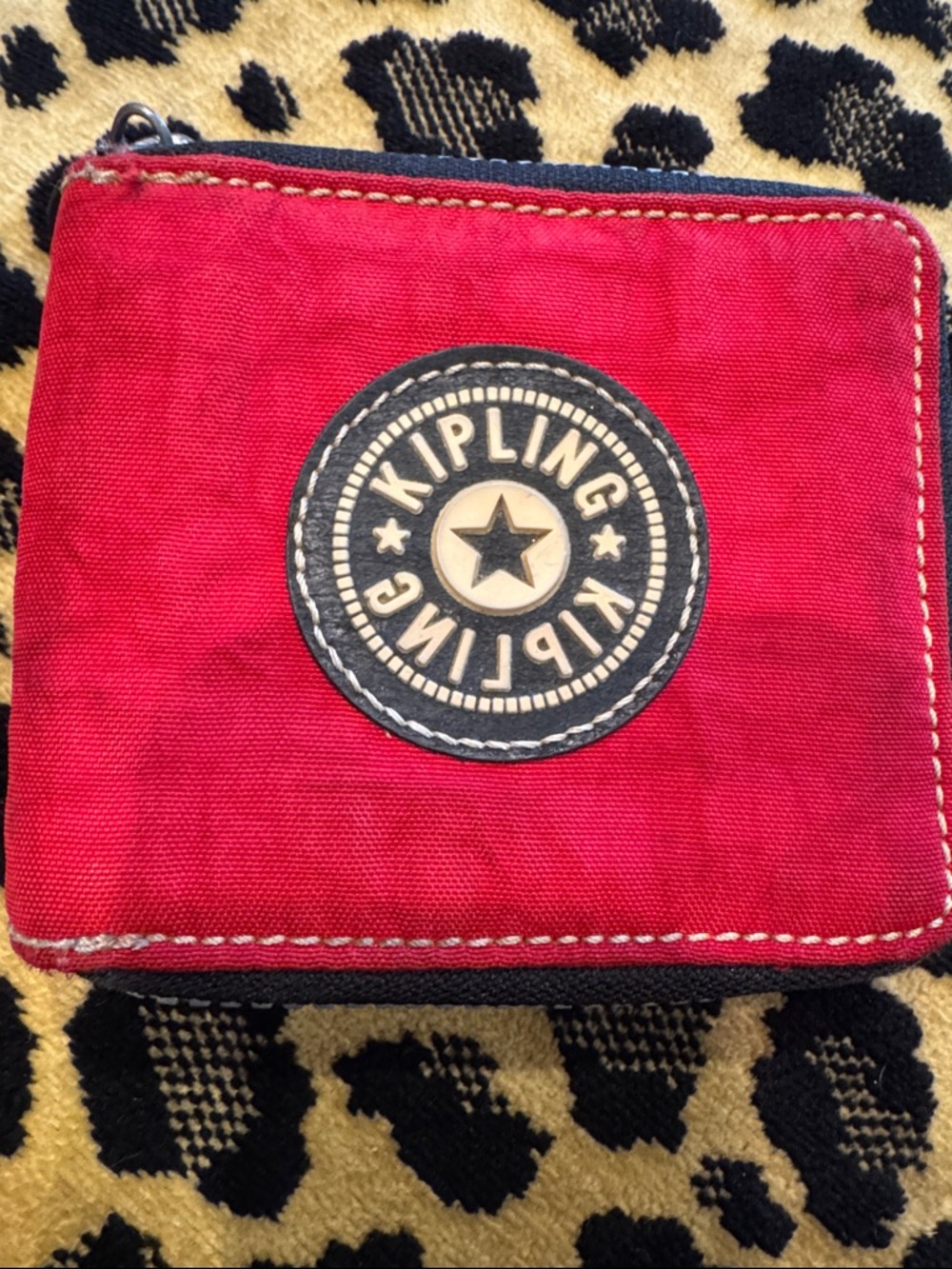 Kipling bright red zip-around coin wallet with navy logo patch